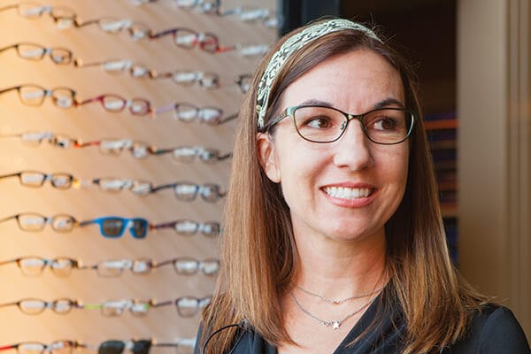 Woman trying on glasses in optical shop